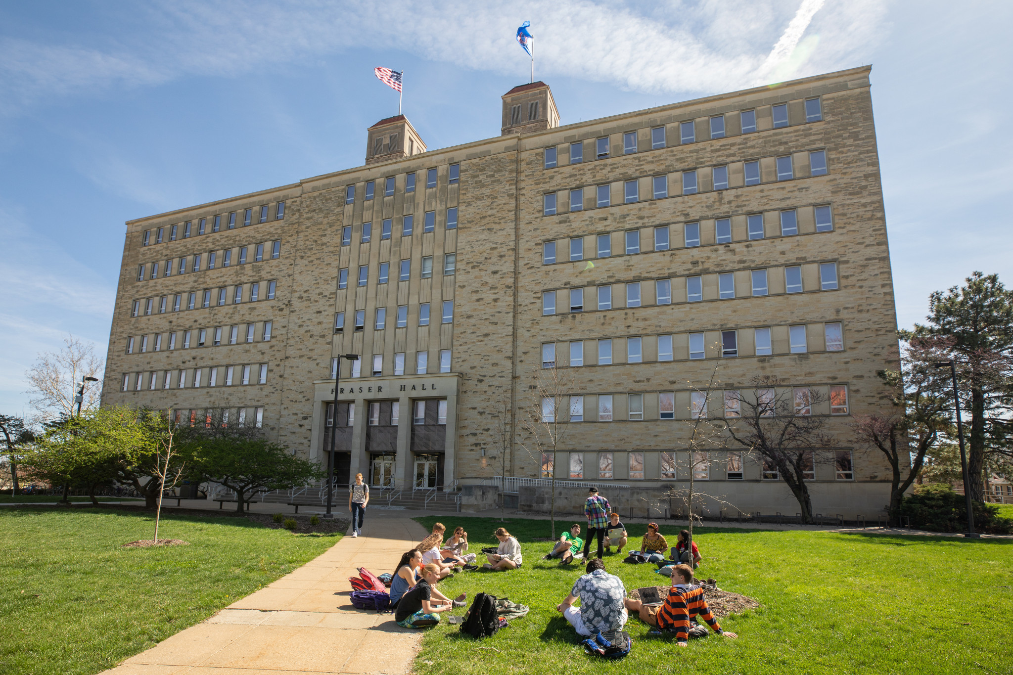 Fraser Hall with students sitting in circle on lawn outside building